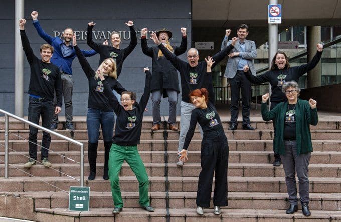 Climate activists celebrating after having won a court case against Shell.